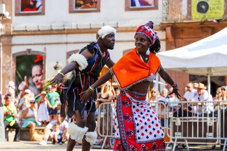Homem a tocar instrumentos tradicionais num festival cultural ao ar livre em Moçambique