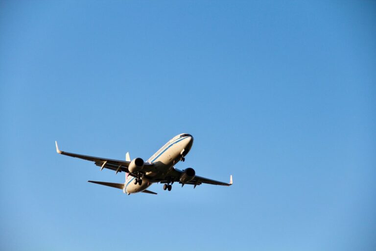 Avião comercial a aterrar numa pista em Moçambique com paisagem tropical em fundo