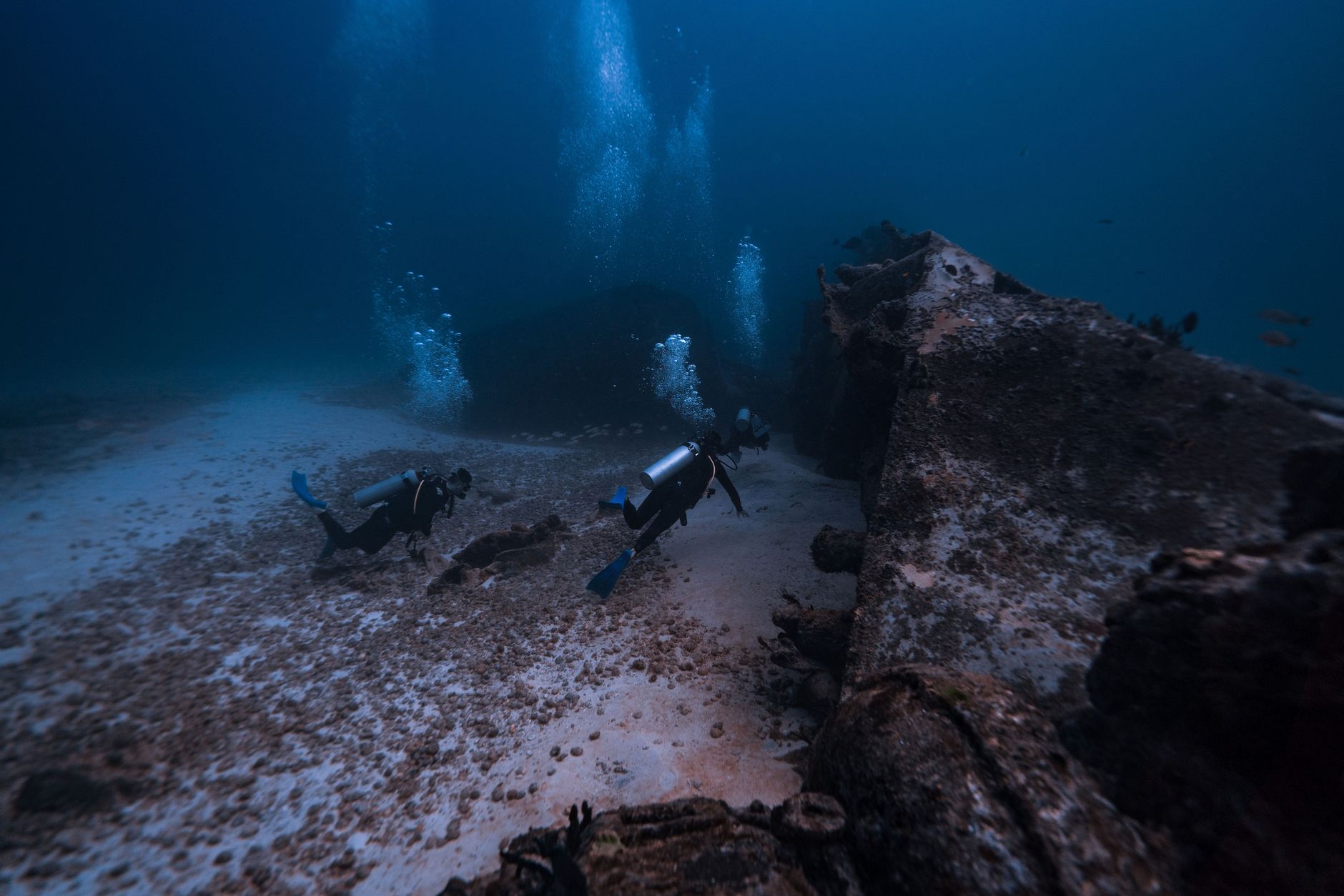 Mergulhador explorando o fundo do mar cristalino em Tofo, Moçambique, com recifes de coral.
