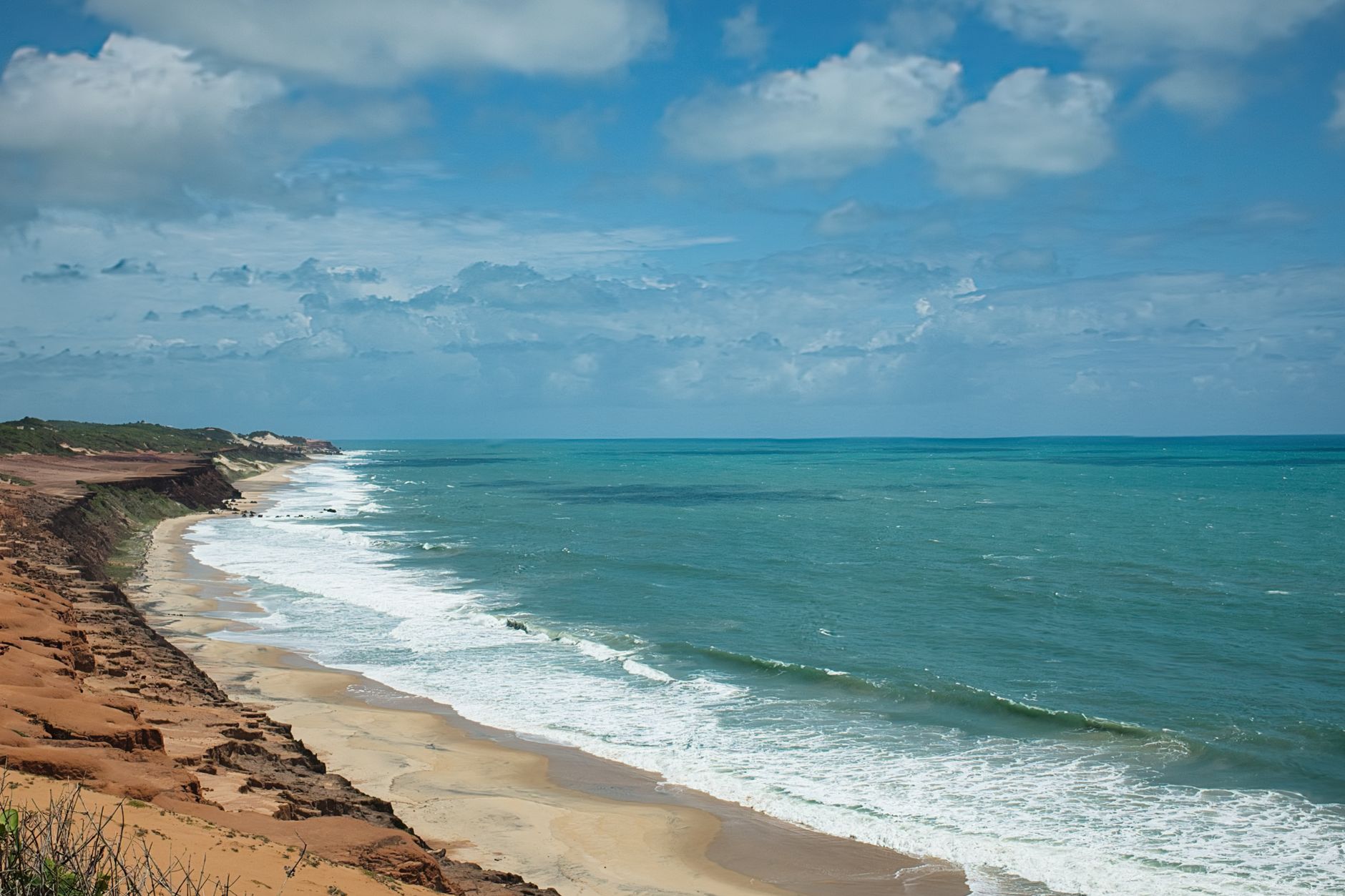 Vista panoramica da extensa faixa de areia dourada da Praia de Tofo com o mar azul turquesa em Inhambane, Mocambique