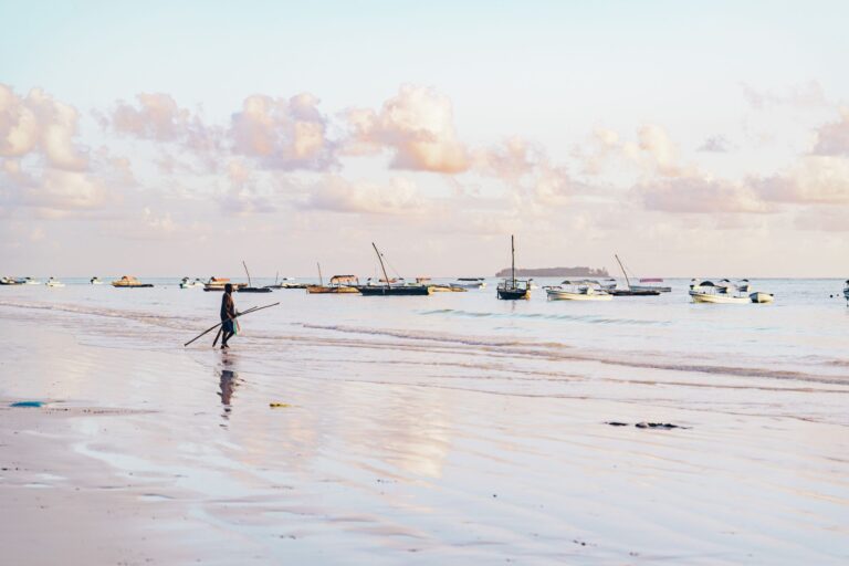 Vista panorâmica das águas cristalinas de Vilankulo em Moçambique com barcos tradicionais ao fundo