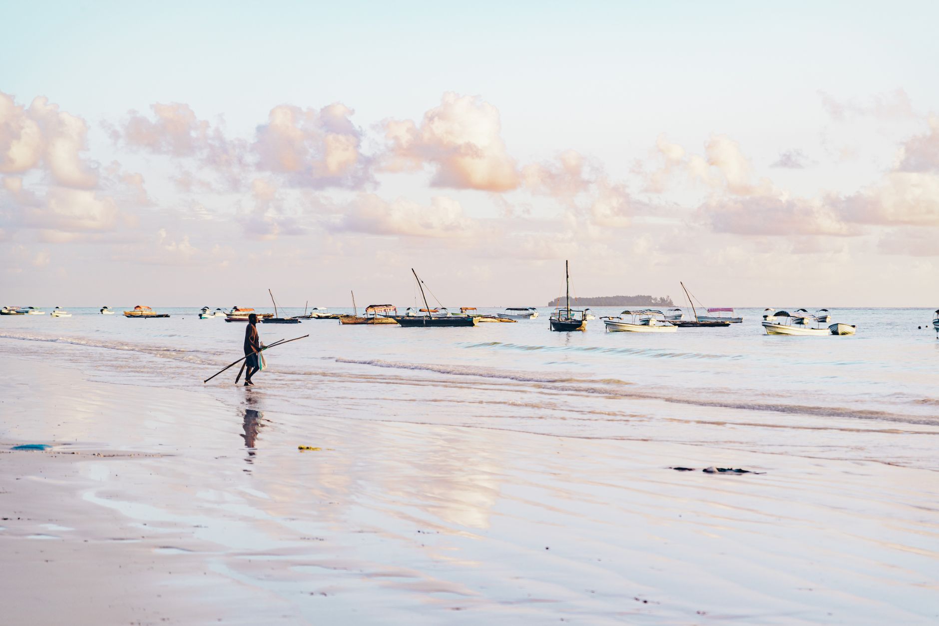 Vista panorâmica das águas cristalinas de Vilankulo em Moçambique com barcos tradicionais ao fundo