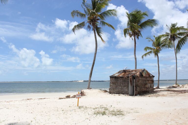 Paisagem costeira de Moçambique com águas cristalinas e dunas de areia branca